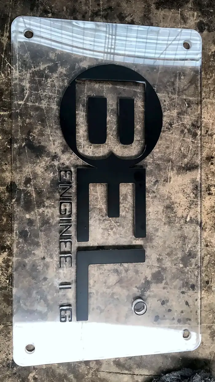 Placa de acrílico transparente con logo en relieve negro